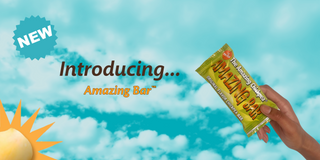 Promotional image of the New Amazing Bar with a kid's hand holding it against a blue sky background.